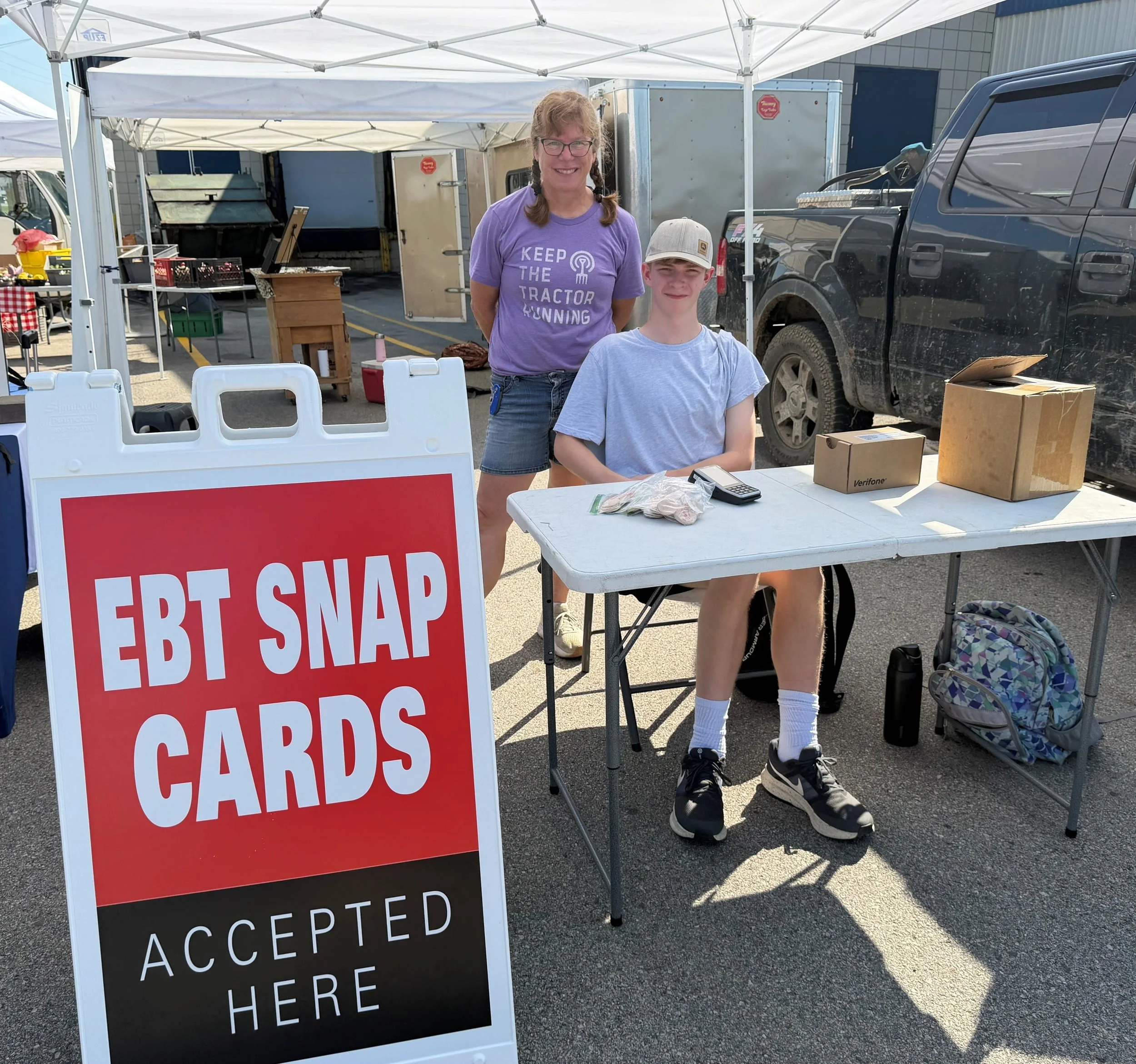 Plainview Farmers Market welcome tent with EBT sign the market manager and the welcome tent staff