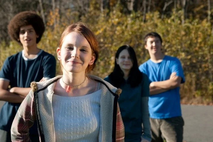 2 female and 2 male teens looking at camera