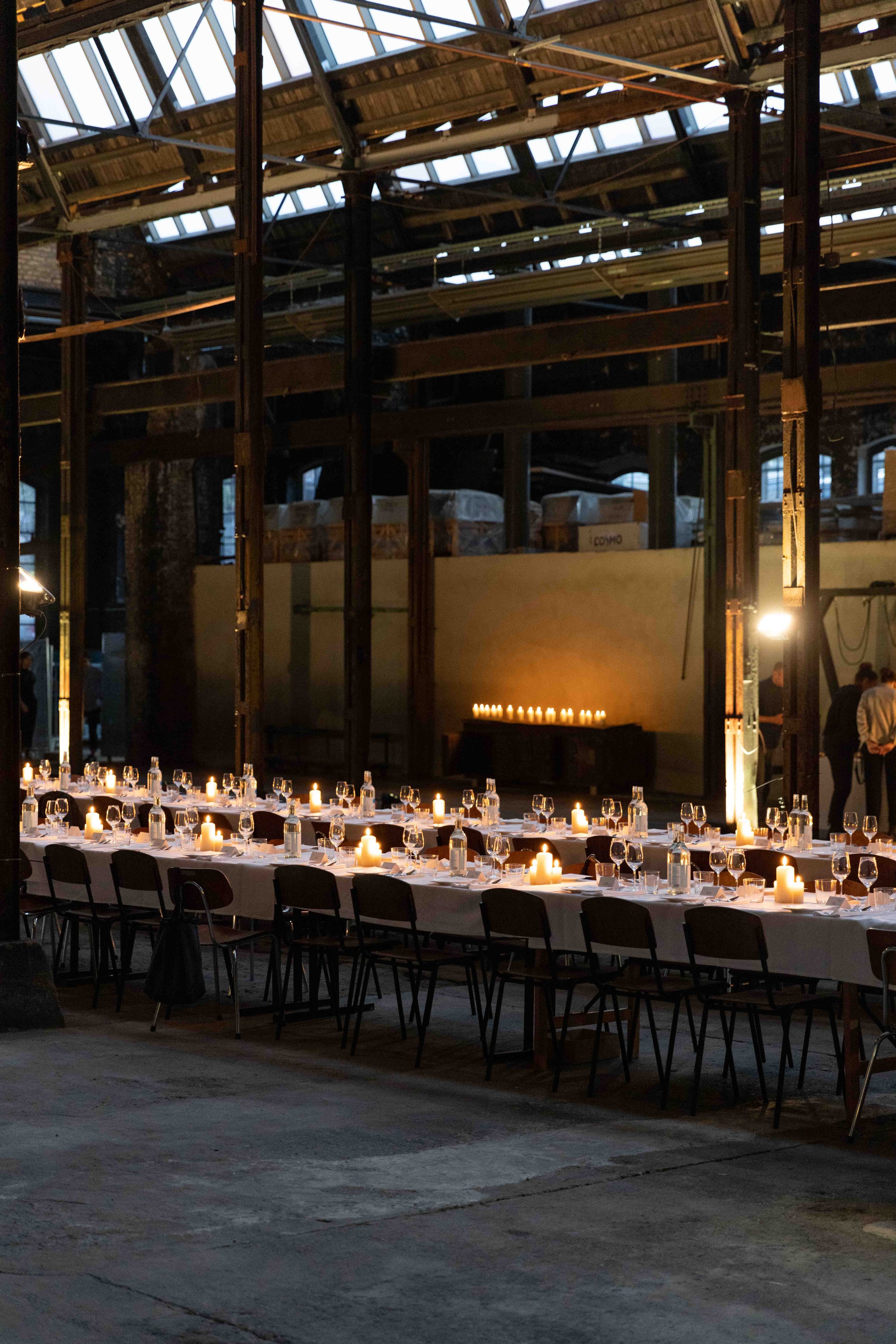 Tafel in einer industriellen Halle mit Kerzenbeleuchtung