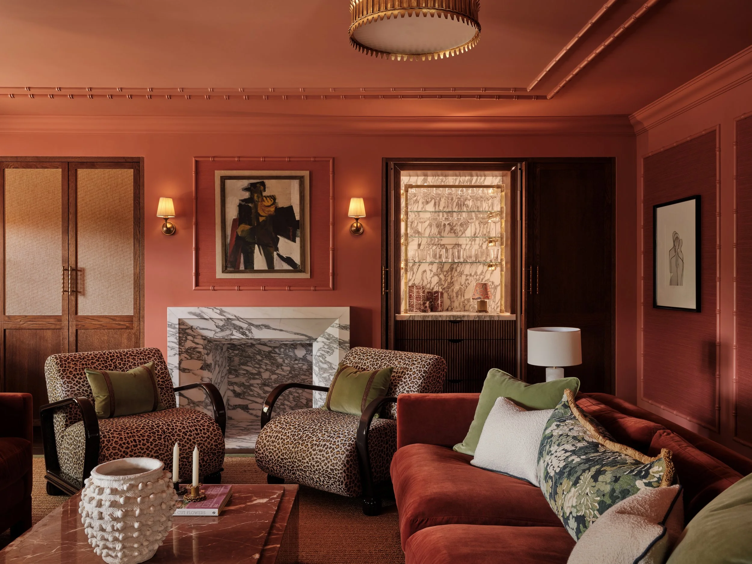 UK cozy family room with marble fireplace, bar cabinet, feature armchairs and artwork