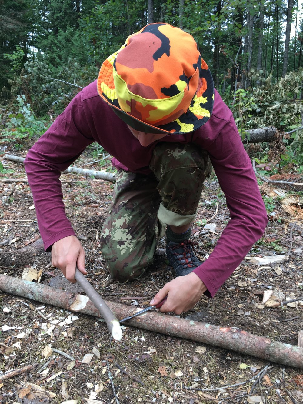 Zander batons his knife to make a pot hook.