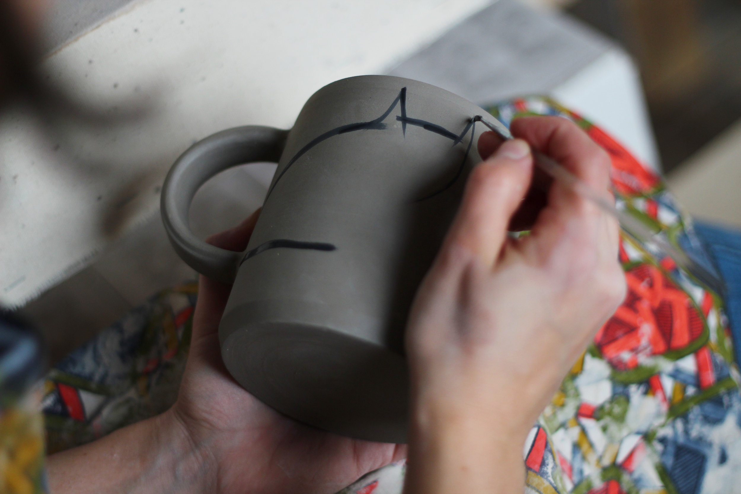 Some pieces, like our cat mug with the tail on the handle, are completely painted by hand, so each one is completely unique and has its own personality! Other pieces have hand-painted details in addition to the engobe dip. These details, like faces and outlines, are hand-painted on with a tiny paintbrush.