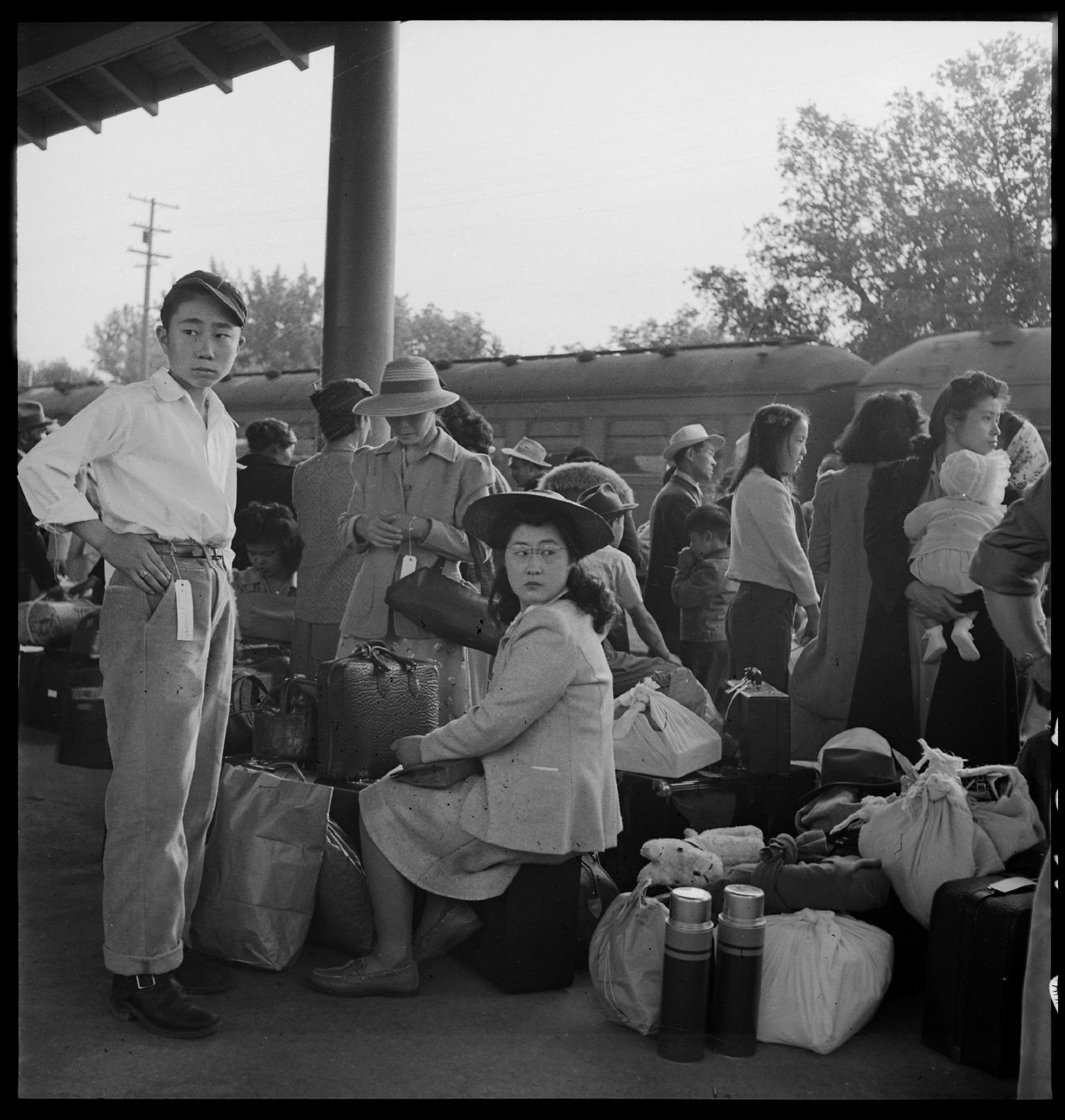 Woodland_CA_Families_of_Japanese_ancestry_with_their_baggage_at_railroad_station_awaiting_NARA_537804.jpg