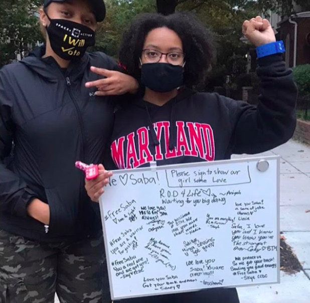 Senior philosophy, politics, and economics major Saba Tshibaka, right, holding a whiteboard of supportive messages pictured with the founder of the Live Movement, Aniyah Vines after Tshibaka&rsquo;s release.  (Saba Tshibaka)