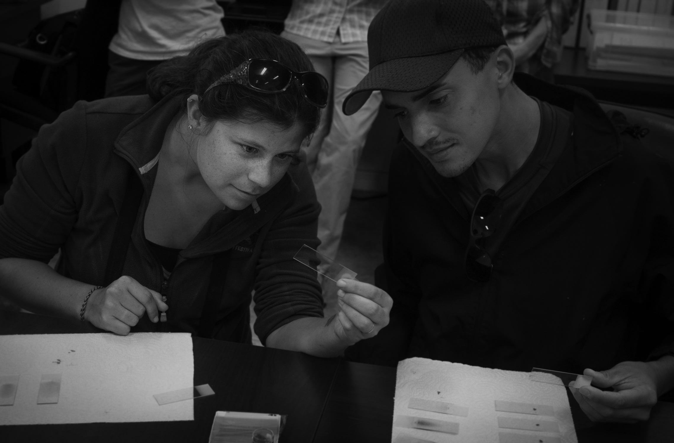 Researchers Emily Angell and Greg Thompson, along with others, learn how to make blood smears.