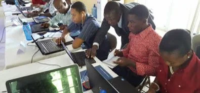 Alia, in dark suit, training Haitians on using the model. Photo provided by Didier Alia.