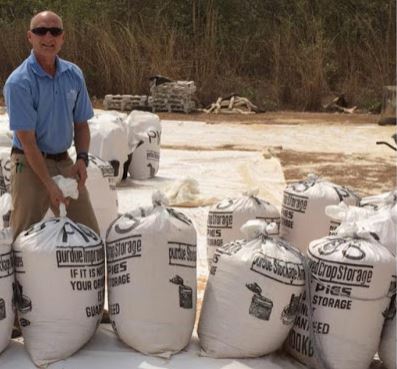 Sam McNeill ties a bag of corn. The PICS bags have two plastic liners, which have to be tied separately to provide an airtight seal. PICS bags were evaluated with four other treatments to compare their performance with untreated corn in a 12-month study. Photo provided by Sam McNeill.