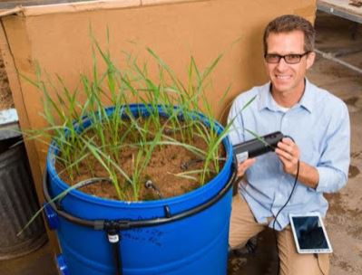 David McNear demonstrates the use of rhizotron, which allows him to view the root system within a mesocosm.