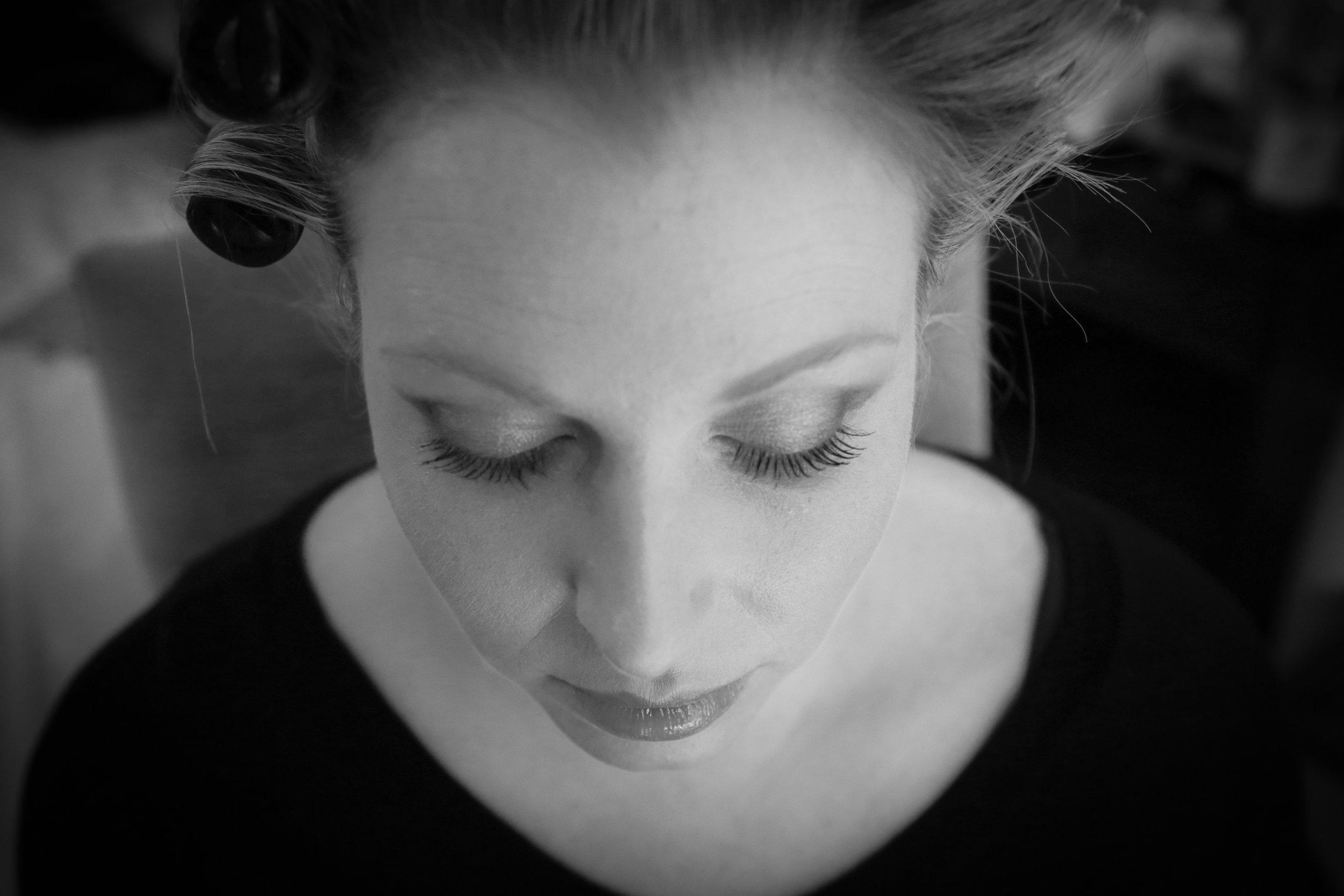Black and white photo of a woman with closed eyes and curled hair