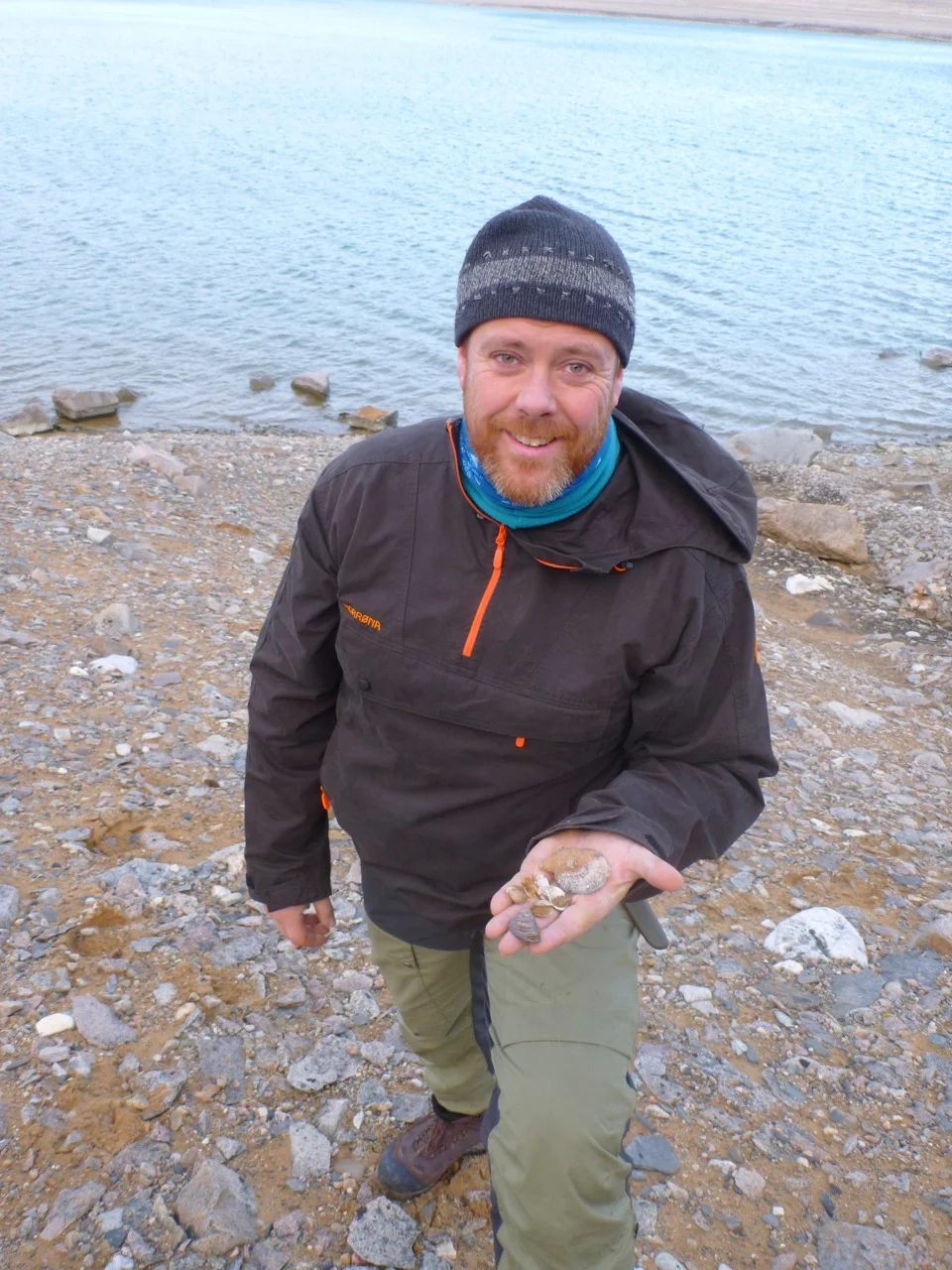 The author with fossil shells from Rijpfjorden in Svalbard. Mussels lived in Svalbard in warm periods after the last Ice Age, but which species lived here then? It has not been possible to isolate DNA from these fossils. Photo: Colin Griffiths / SAMS