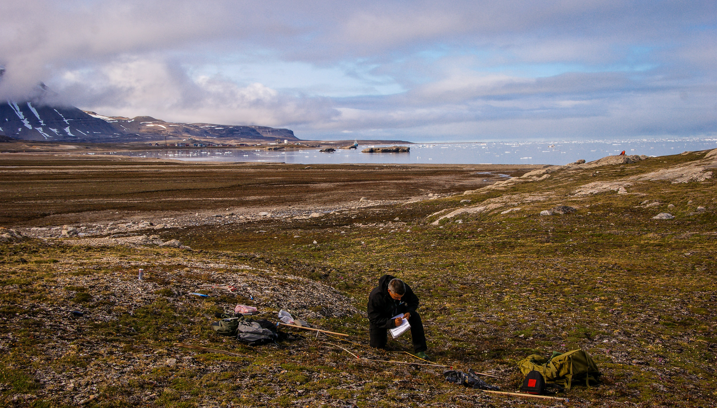 Senior researcher in ecology Jarle W. Bjerke is doing fieldwork on Svalbard. Kongsfjorden and Ny Ålesund in the background.  JONAA©Trond Johnsen