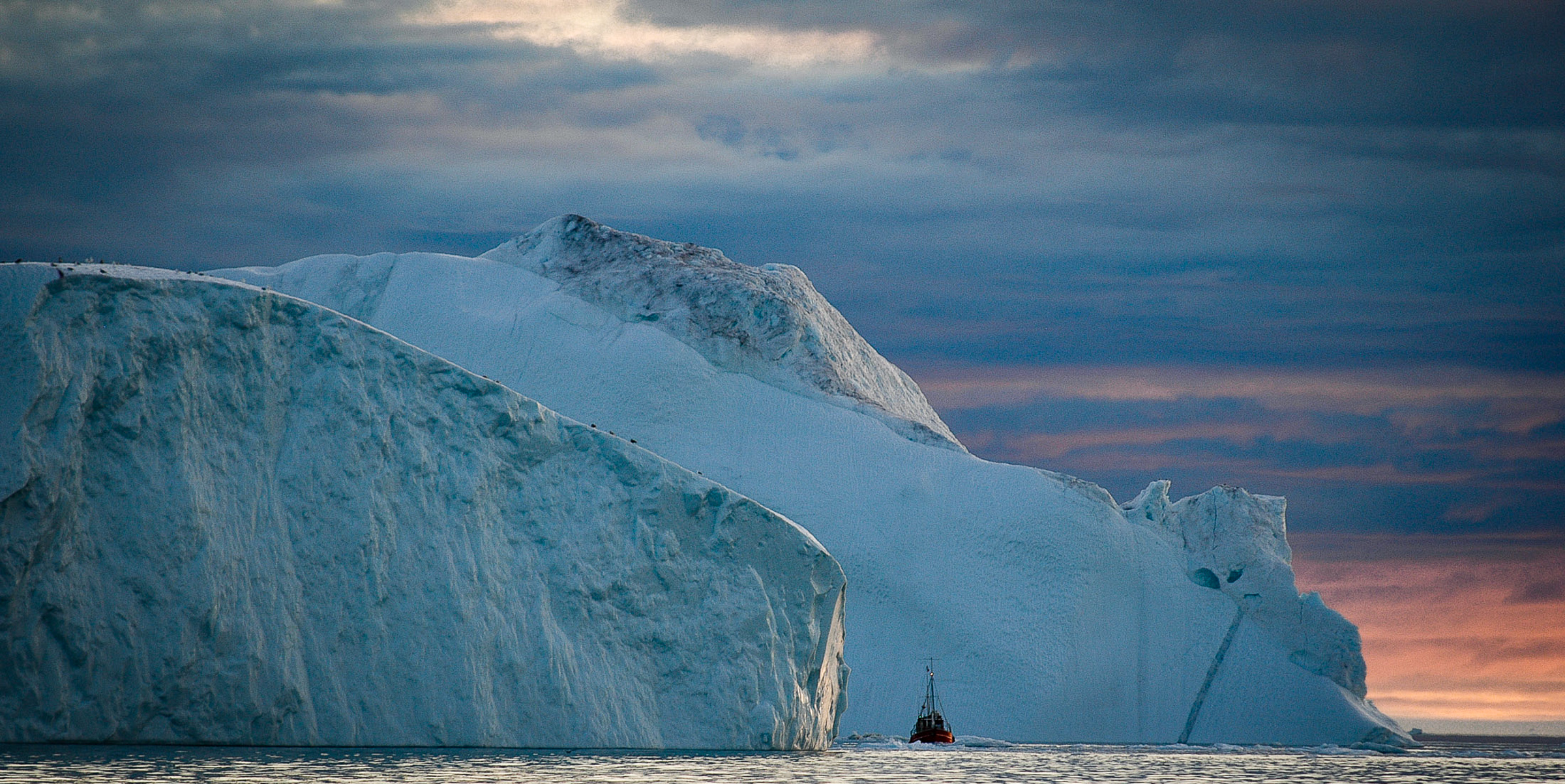 Sailing out of the iceberg cluster under the midnight sun.  JONAA©Kristjan Fridriksson