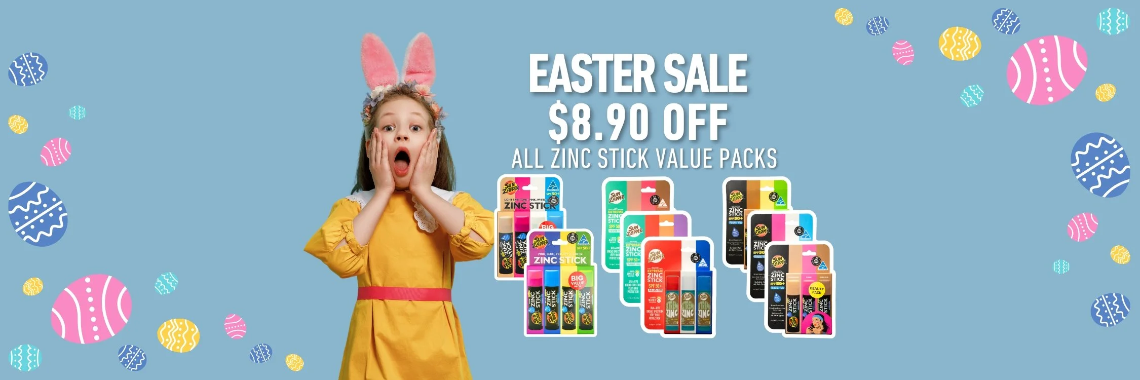 Young girl wearing bunny ears and a yellow dress with pink sash, with hands on face, celebrating Easter sale on zinc stick packs with colorful packaging, on a blue background with scattered Easter eggs.