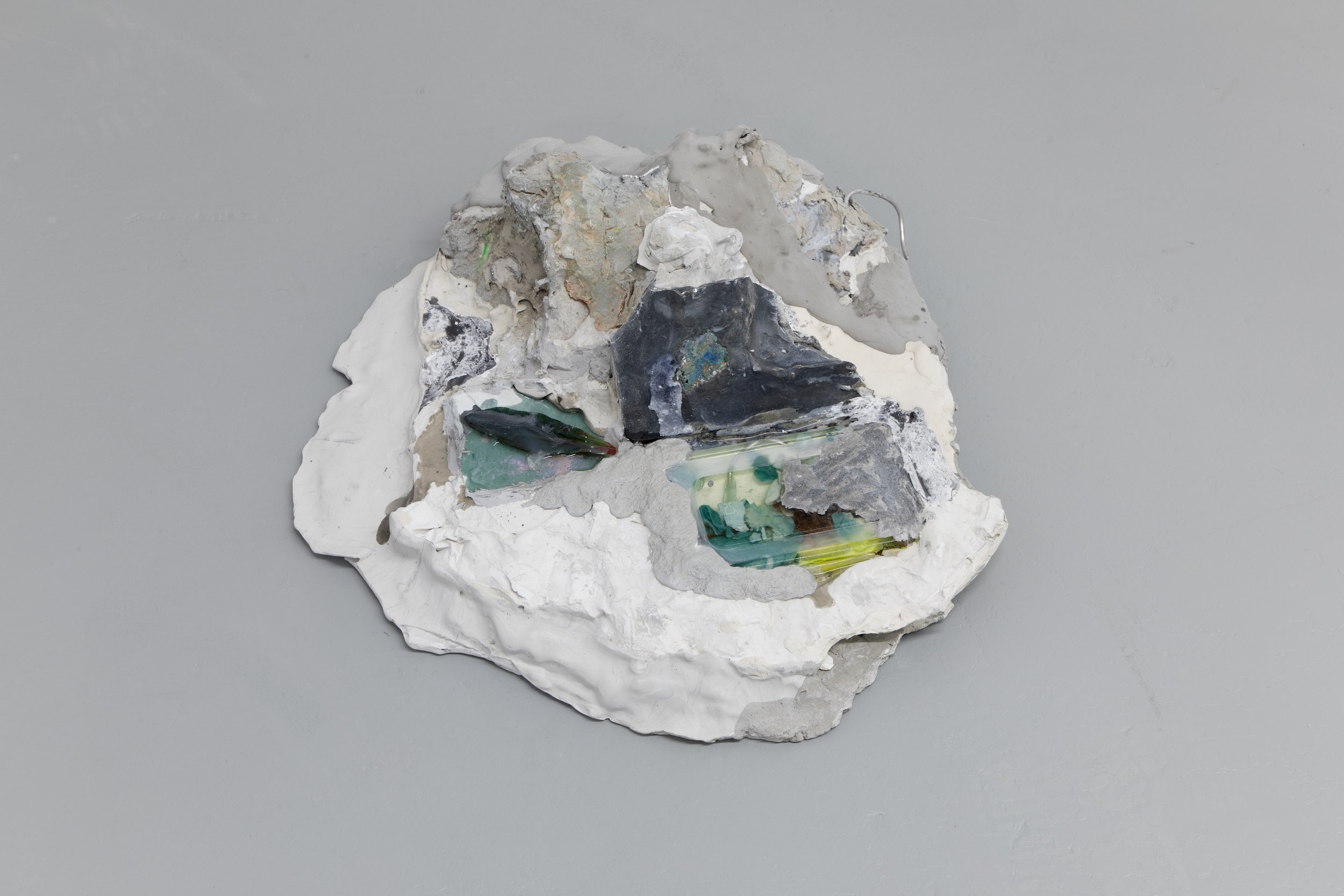  Laur P,  When the rays sweat a softer kind of anger , 2024, Plaster, cement, paper pulp, dry pigments, metal wire, plastic glass, plastic sheet, solder metal, plastic lid, epoxy resin, oil-based ink, dead leaf, oil paint residues, two pills of Cital