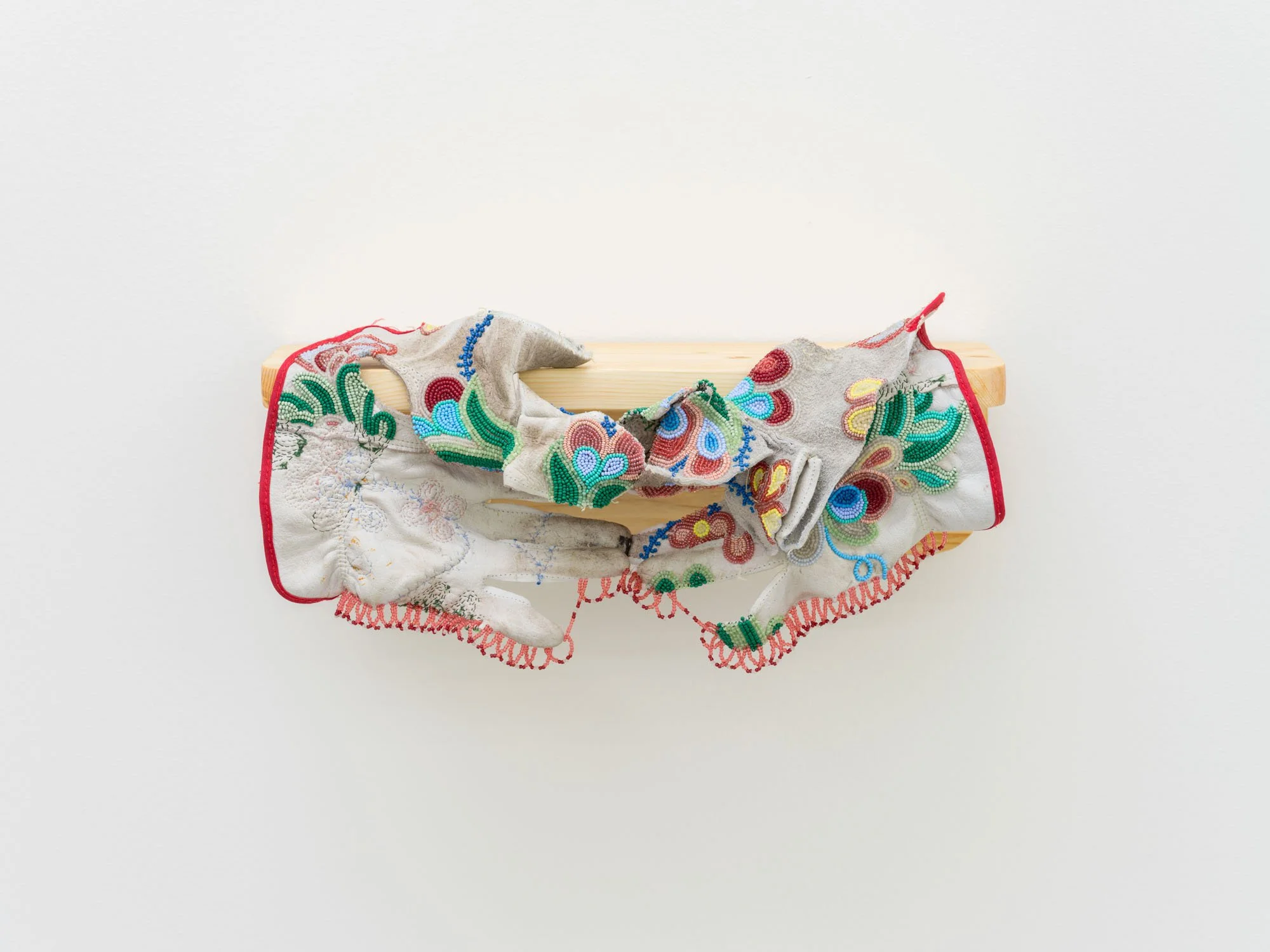 Haley Bassett,  Valænce , 2025, Vintage and contemporary seed beads, thread, imitation sinew, worn work gloves, spruce shelf, 20.3 x 39.4 x 20.3 cm (8 x 15.5 x 8 ")