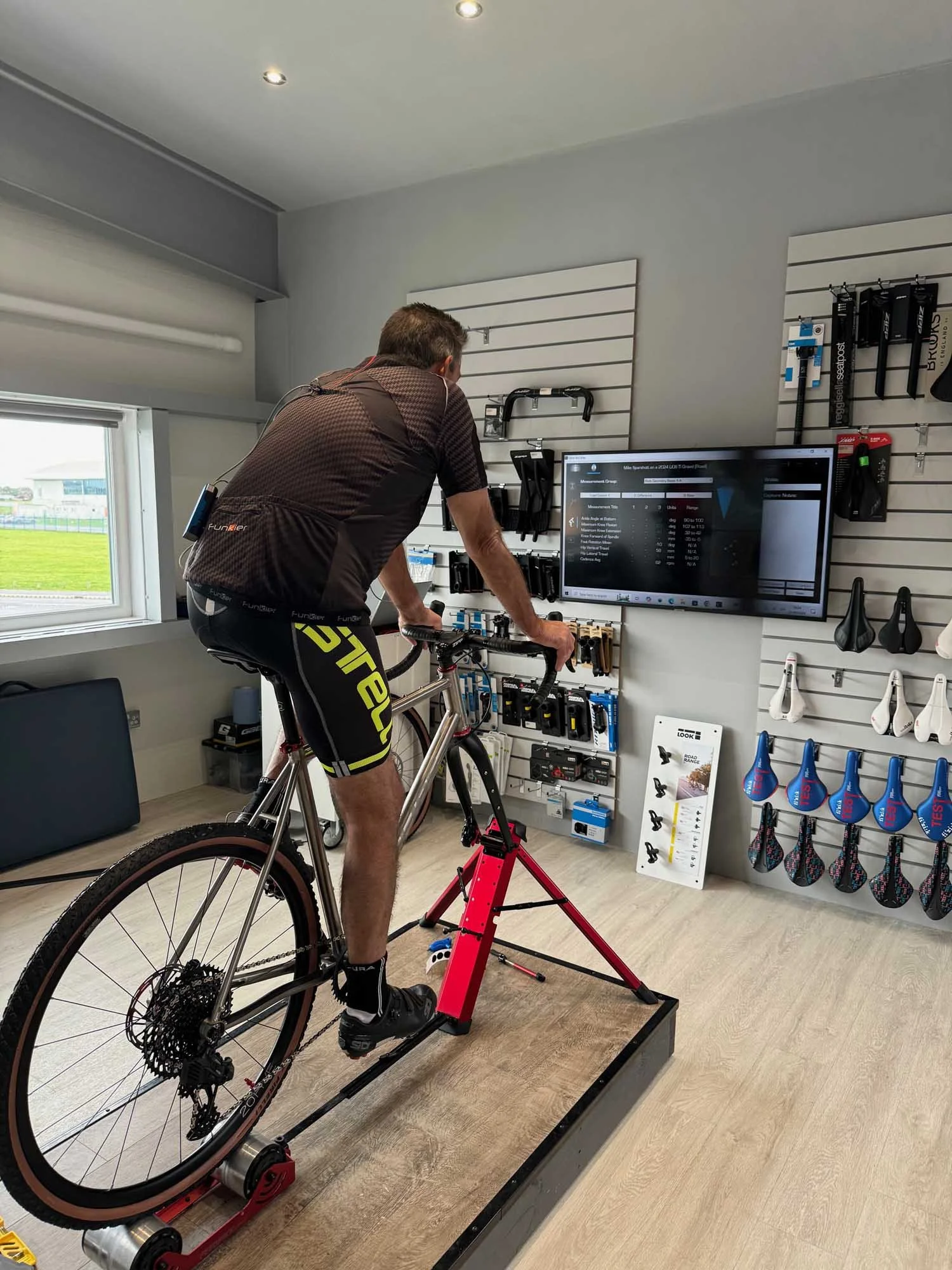 Image of a male cyclist on his LIOS Titanium Gravel bike having a Retül 3D motion analysis bike fit at the LIOS Bike Fit Studio.