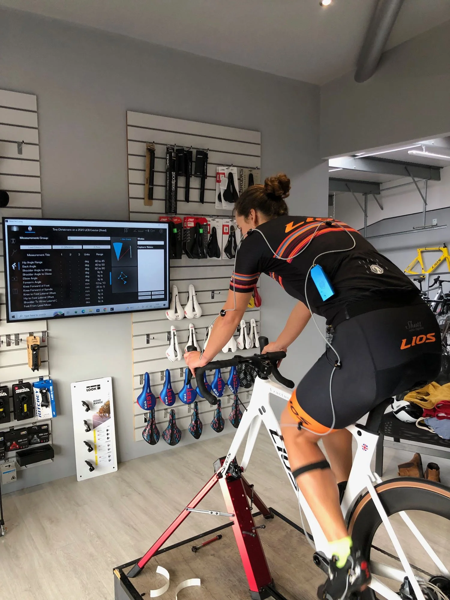 Image of a female cyclist on her LIOS Exactor carbon aero road bike having a Retül 3D motion analysis bike fit at the LIOS Bike Fit Studio.