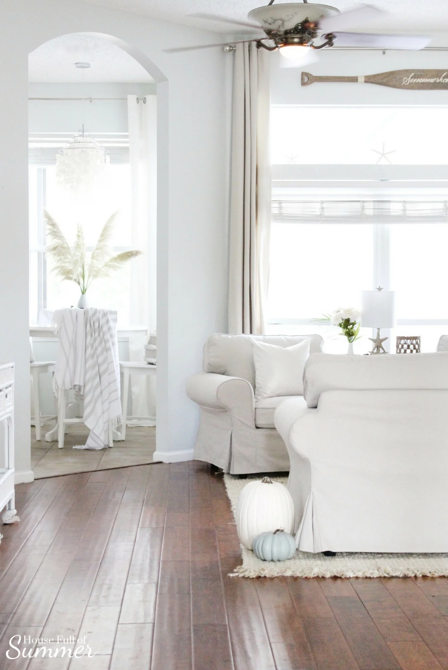 House Full of Summer: Fall Home Tour Blog Hop - Cozy, Coastal, Chic Living Room fall decorating ideas. Neutral interior, living room decor, white pumpkins, blue pumpkins, beige living room ideas, striped throw, breakfast nook, white chandelier