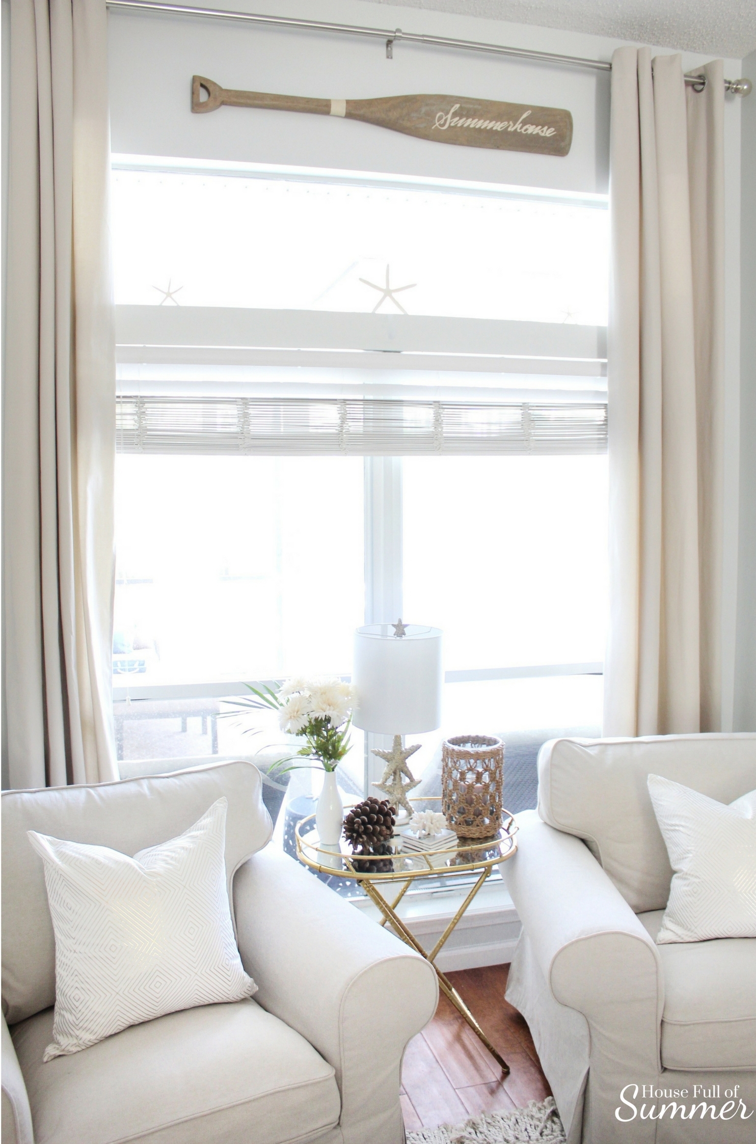 House Full of Summer: Fall Home Tour Blog Hop - Cozy, Coastal, Chic Living Room fall decorating ideas. Neutral interior, living room decor, gold bamboo folding table, mirrored side table, throw pillow covers, faux fall florals, living room ideas, sitting room, wood floors, table styling, pine cones, starfish, coastal table lamp