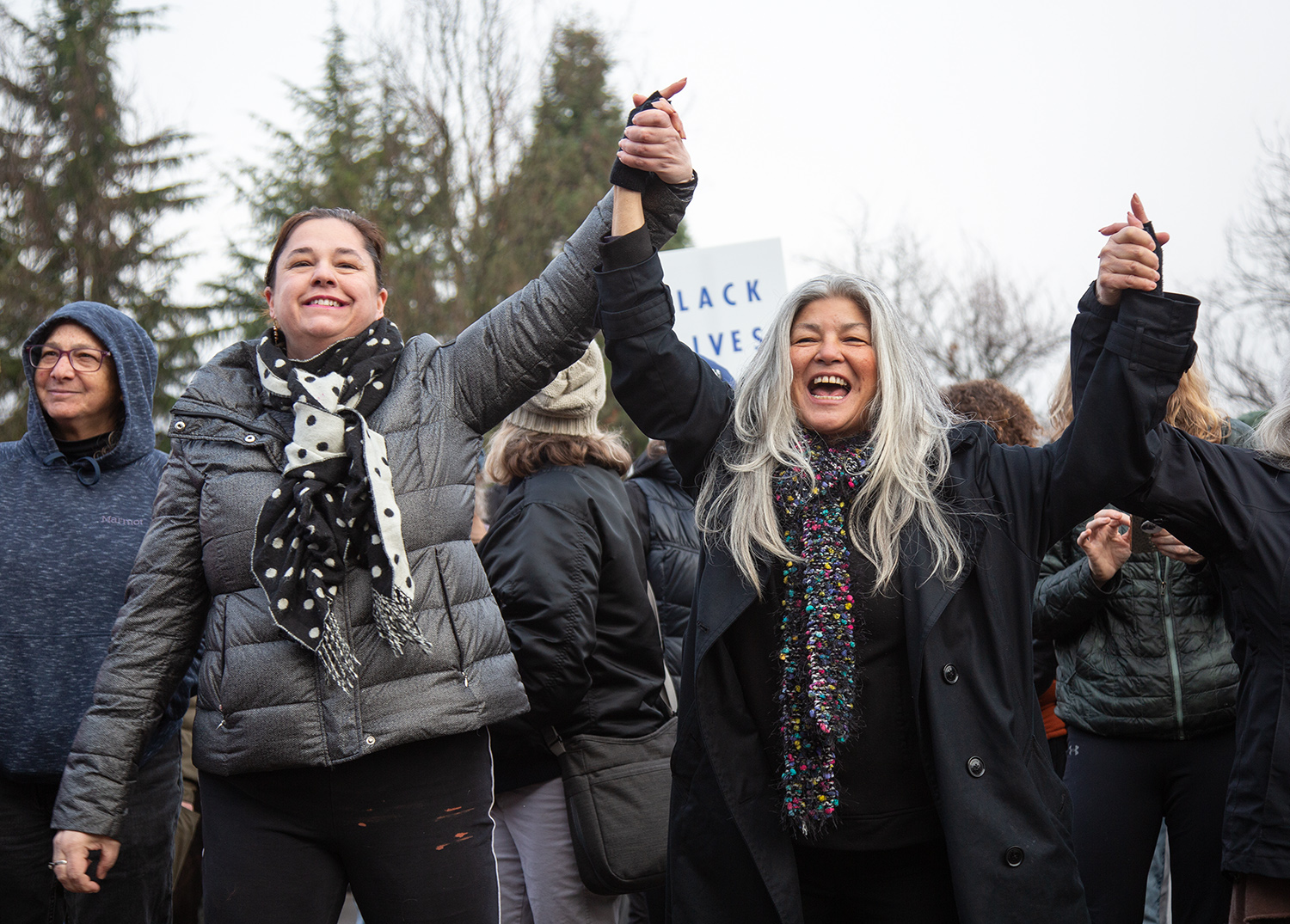  Sabrina Sanchez and Sage Silverstein, left, and Sabrina Sanchez clasp hands as a choir sings during a Martin Luther King Jr. rally outside Autzen Stadium Monday, Jan. 21, 2019, in Eugene. Sanchez said she sees turmoil and mistrust in the national di