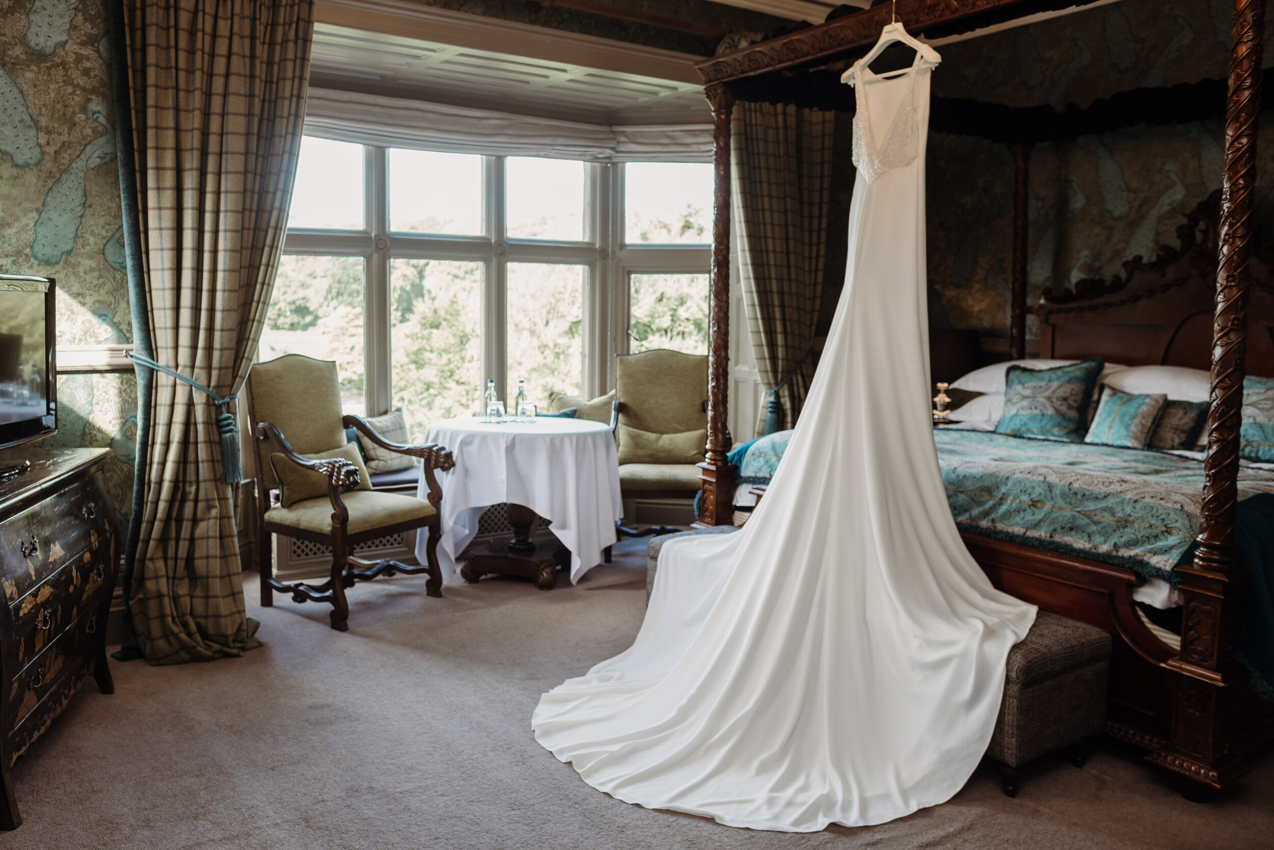 Wedding dress hanging on four poster bed