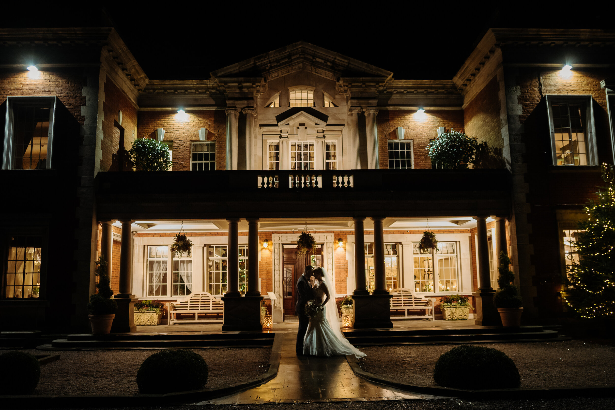 Bride and groom with Eaves Hall as their backdrop at night