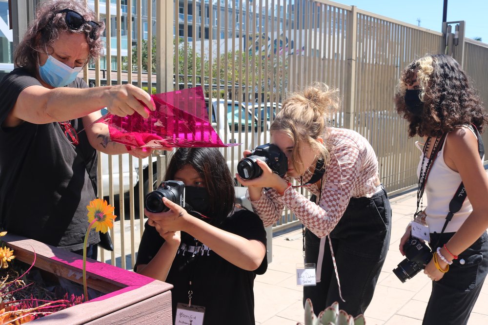  Teaching Artist Jennifer sets the shot using a pink gel. 