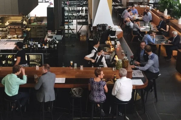 Custom bar top with Coal Buffalo dECOLeather Recycled Leather Veneer by Formica Group panel insert in Brisbane, Australia. Note that the same leather is also used on the table tops. 