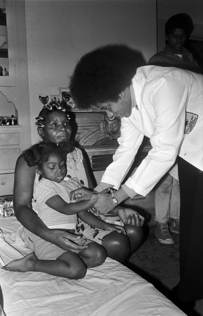 Black Panther member attends to a young girl. Photo: Stephen Shames/Polaris.