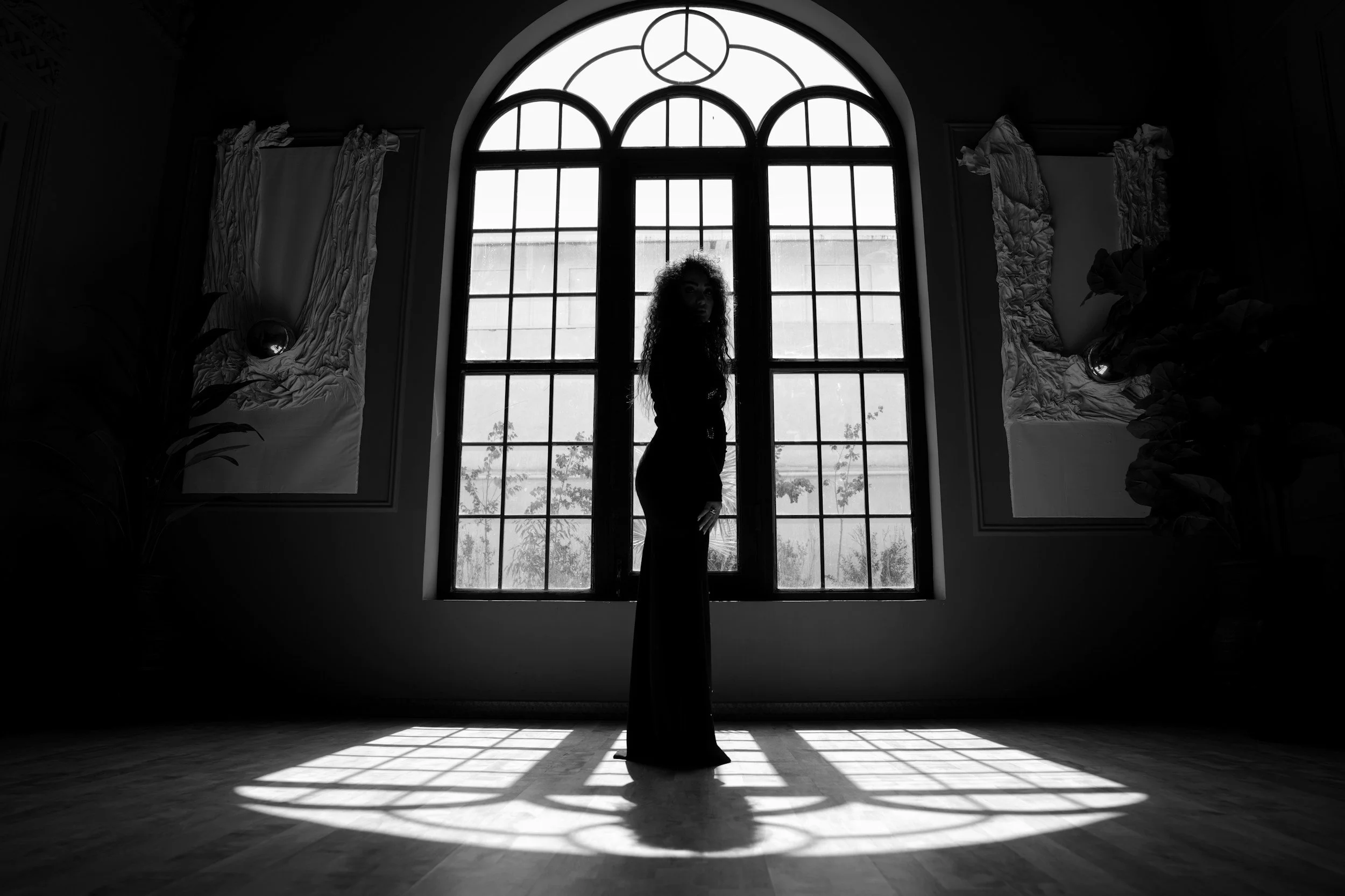 woman standing by the window black and white