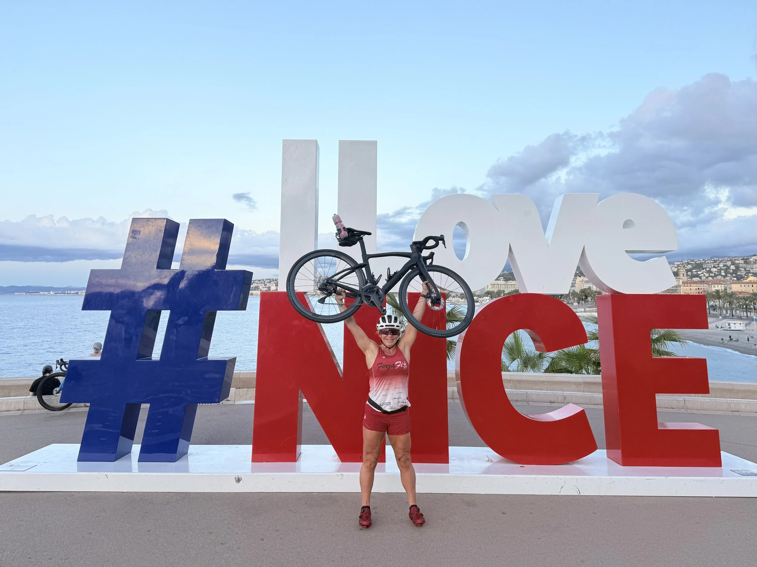 Rosa Laura Saggese Elbooz with Black Forza, her Pinarello F7 rental bike, at the I Love Nice sign before the 2026 IRONMAN 70.3 World Championship in Nice, France
