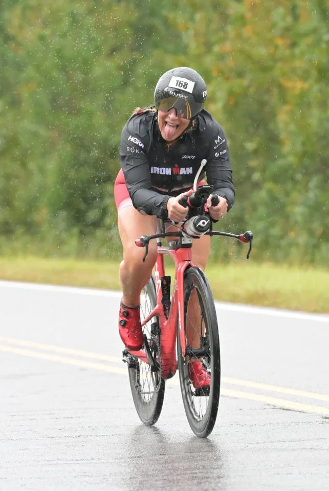 ForzaFit coach Rosa Laura racing her triathlon bike in heavy rain at IRONMAN 70.3 North Carolina 2026, earning the fastest bike split in her age group.