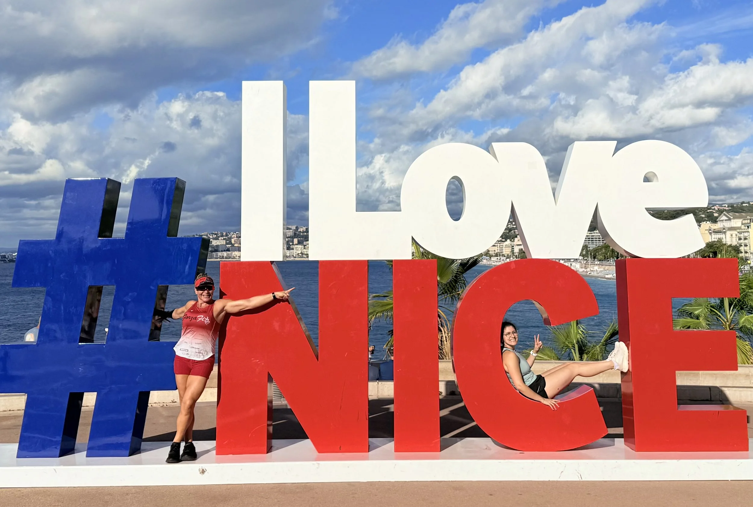 Rosa Laura Saggese Elbooz at the I Love Nice sign overlooking the Mediterranean during 2026 IRONMAN 70.3 World Championship week in Nice, France.