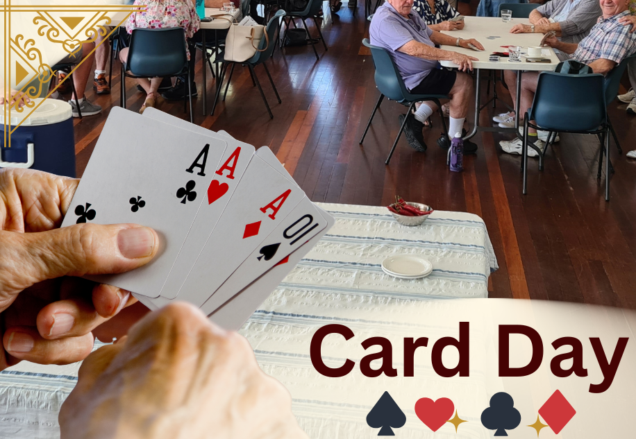Close-up of a hand holding four playing cards showing four aces: ace of spades, ace of hearts, ace of diamonds, and ace of clubs. In the background, senior people are sitting at tables in a community center or clubhouse, engaged in social activities. The text "Card Day" is overlaid on the bottom right corner of the image, with card suit symbols beneath it.