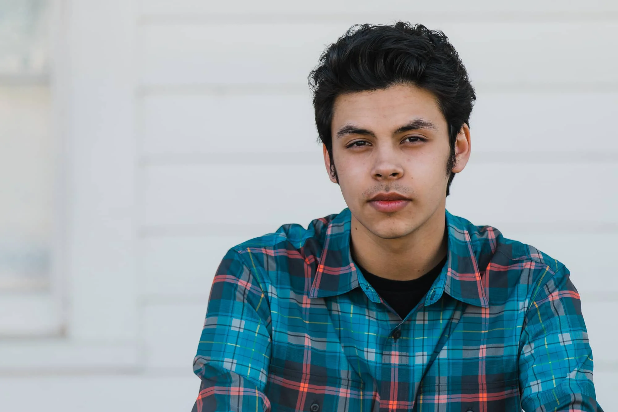 Headshot of young man sitting on a porch.
