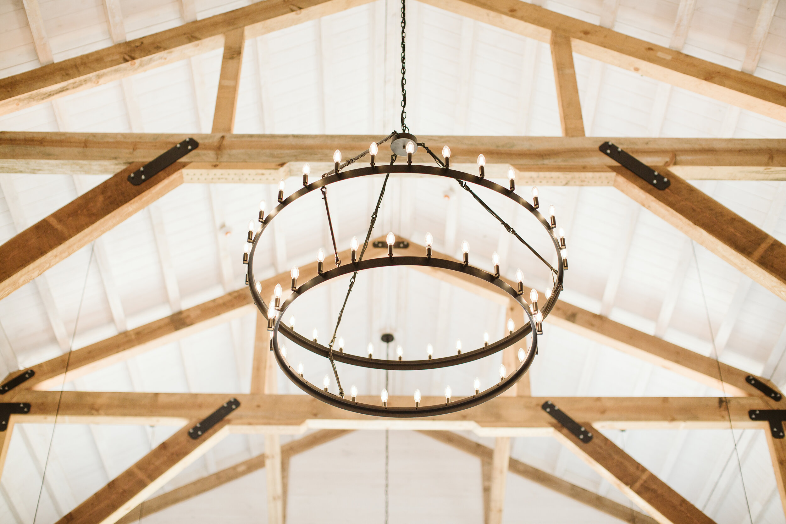  [PHOTO] One of three chandeliers in the Gambrel Room, featuring candle lights circling two metal rings 