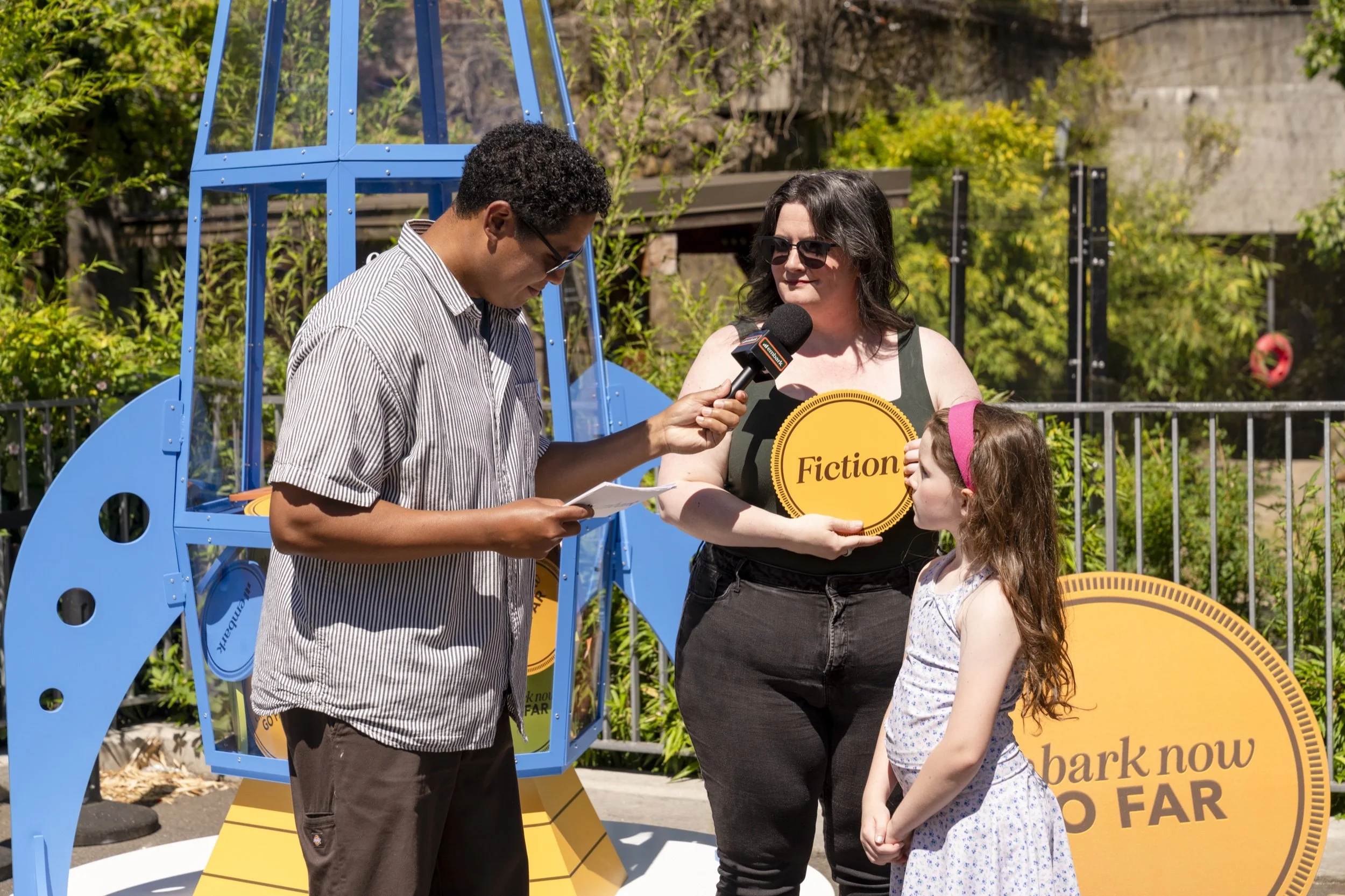 A family participates in an Embark interview beside the rocket installation.
