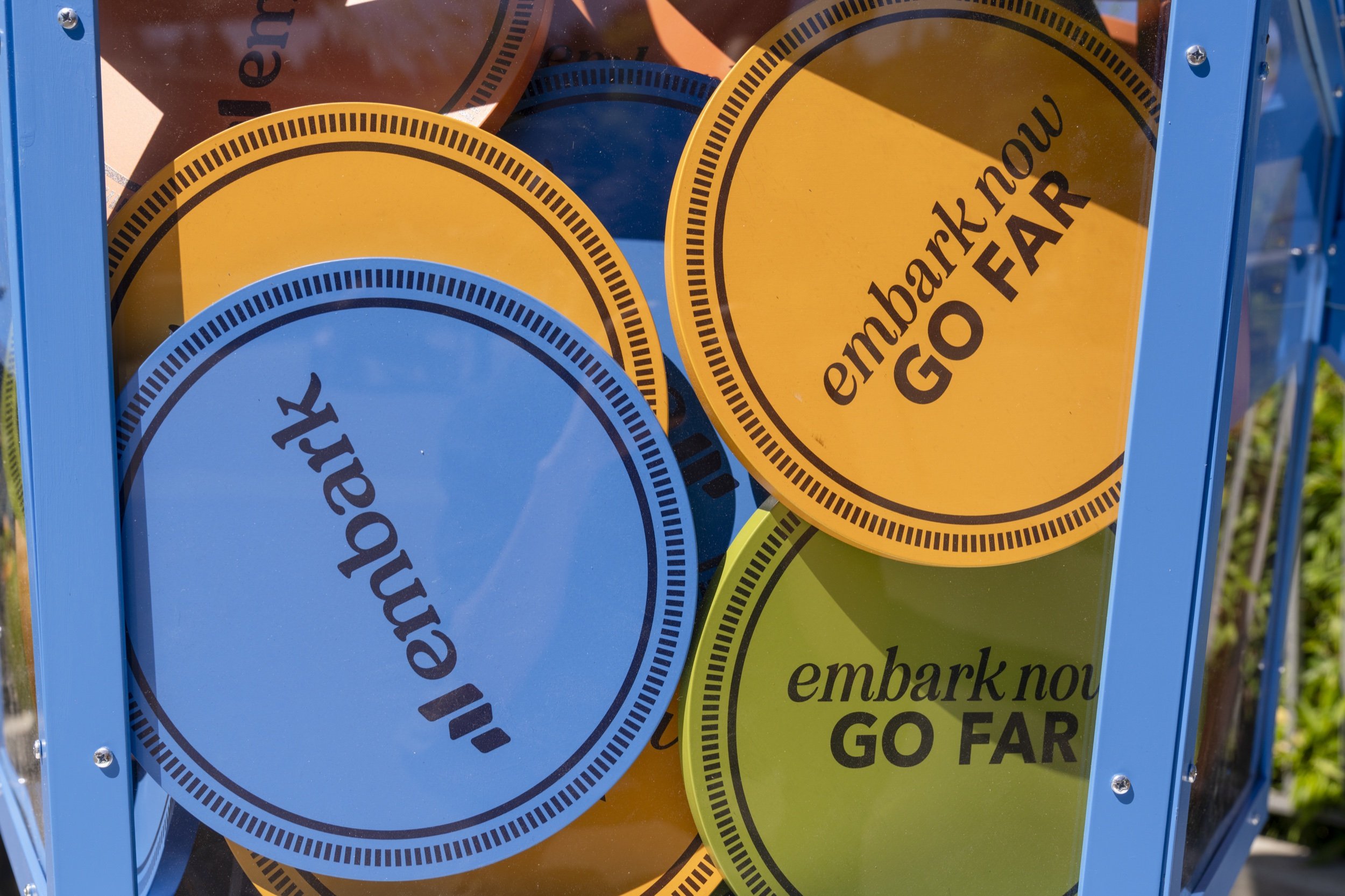 Close-up of colorful oversized Embark Now, Go Far coins inside the rocket.