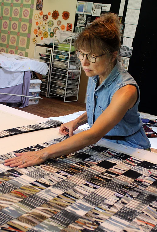 Assembling strips of dyed, fused silk for Tall Grass I quilt textile .