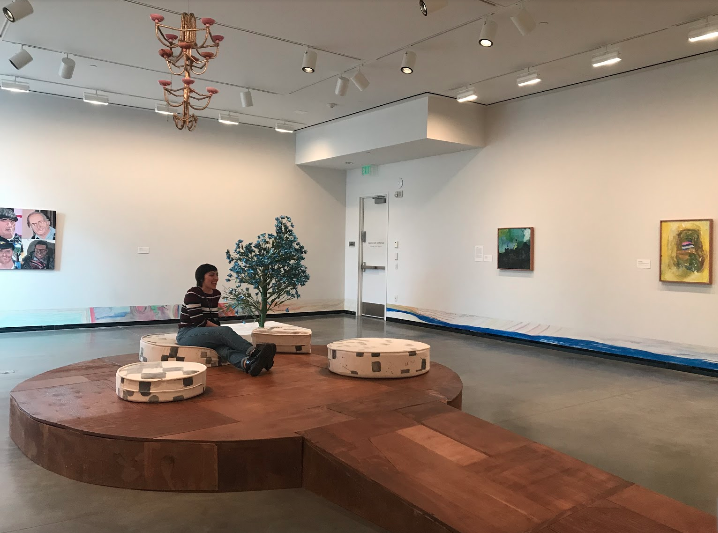 A view of the stage constructed by Johanson and Jackson being tested by Lily Wilson, a friend of the author’s. Lawrence Oliver’s “A Flower Tree”, 2013, constructed of paper, paint, packing tape, bamboo, and hot glue, also seen.