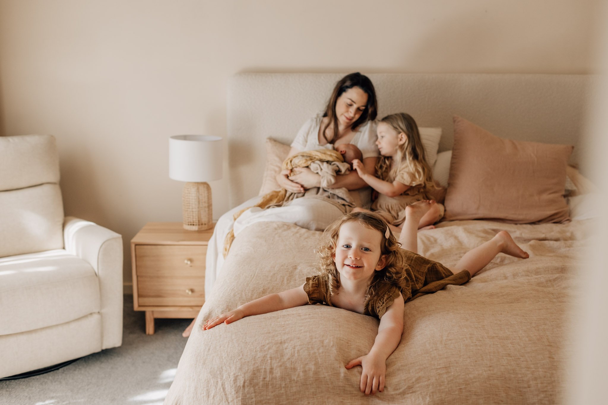 Young Geelong family on large bed (two small girls, baby and their mother).jpg