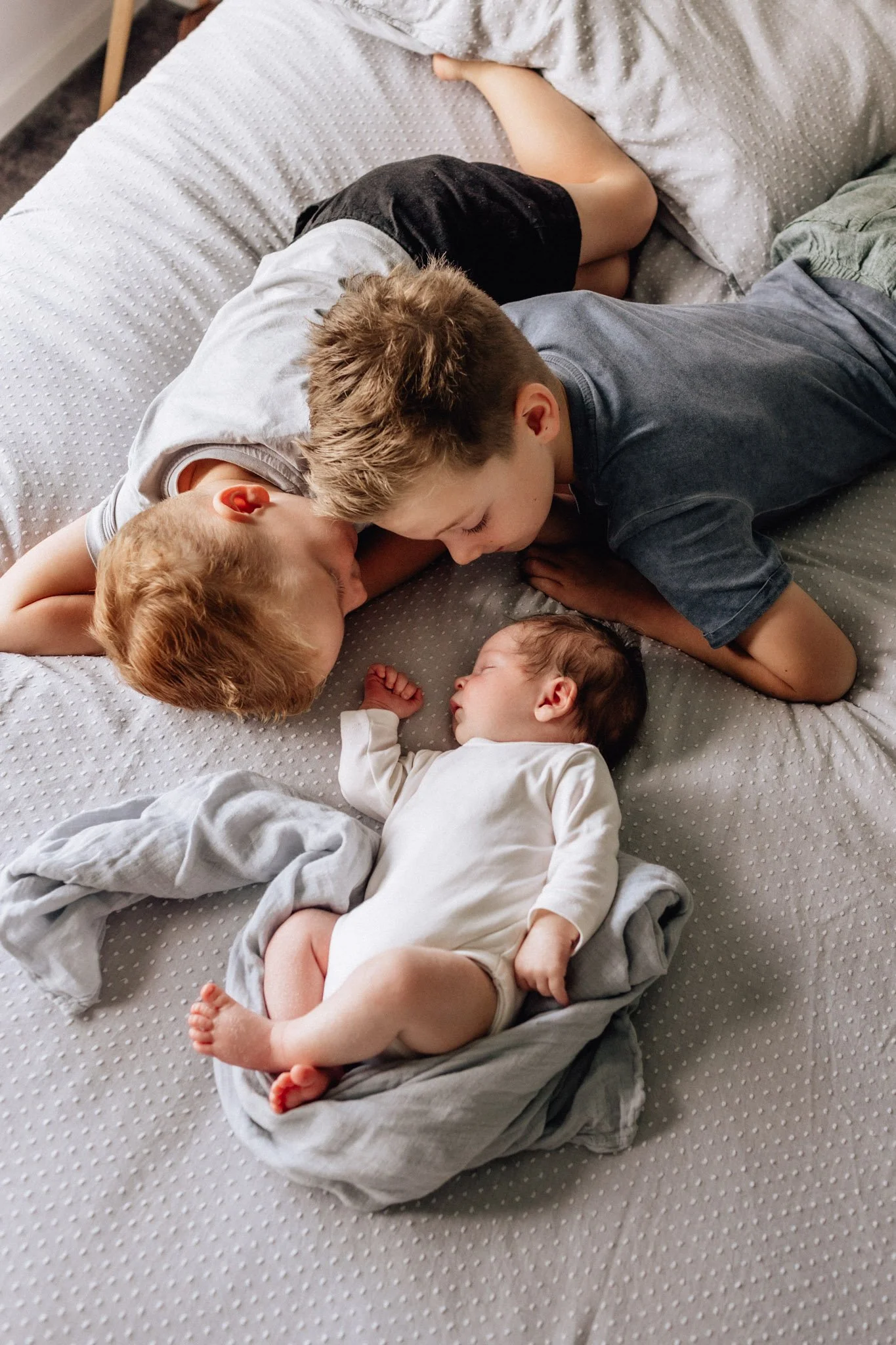 brothers looking at newborn baby