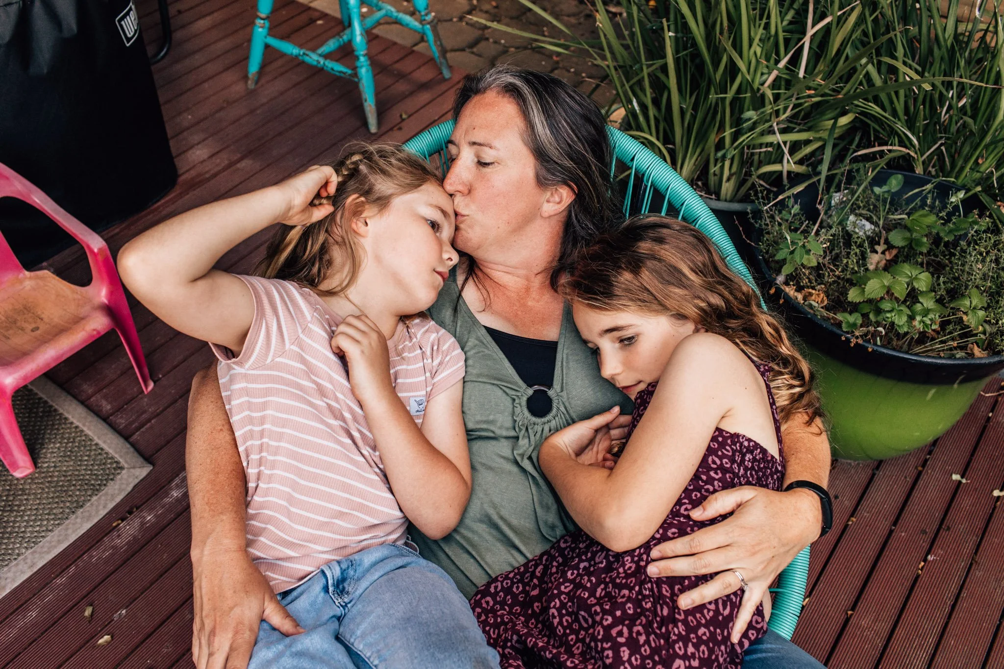 Geelong sisters cuddling with their mother outside