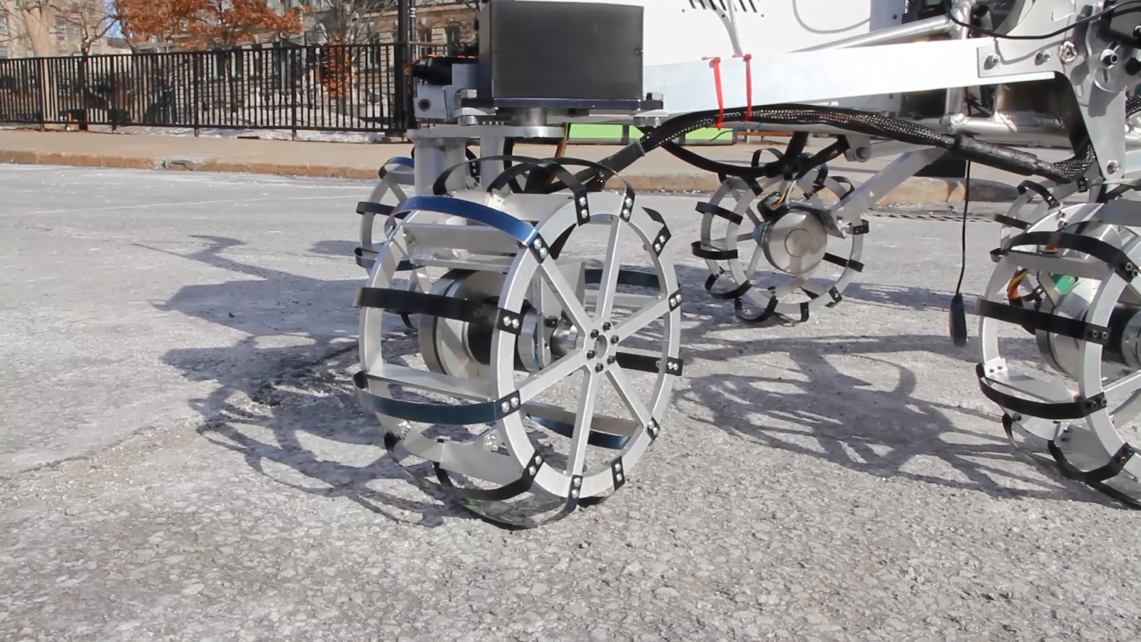 Each wheel is composed of spring steel spokes for navigation on hard terrain and over obstacles, and inner paddles to drive in sand.