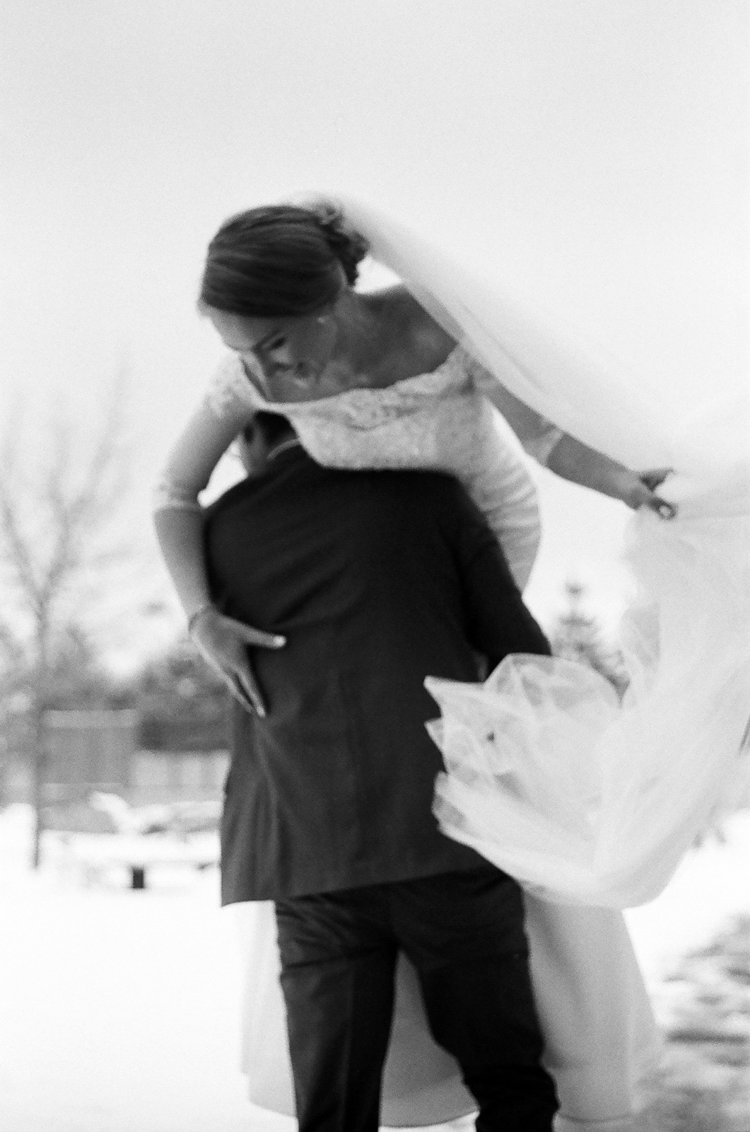 Black-and-white photograph Groom carrying his bride on their wedding day in Snowy Mountains of Albuquerque New Mexico