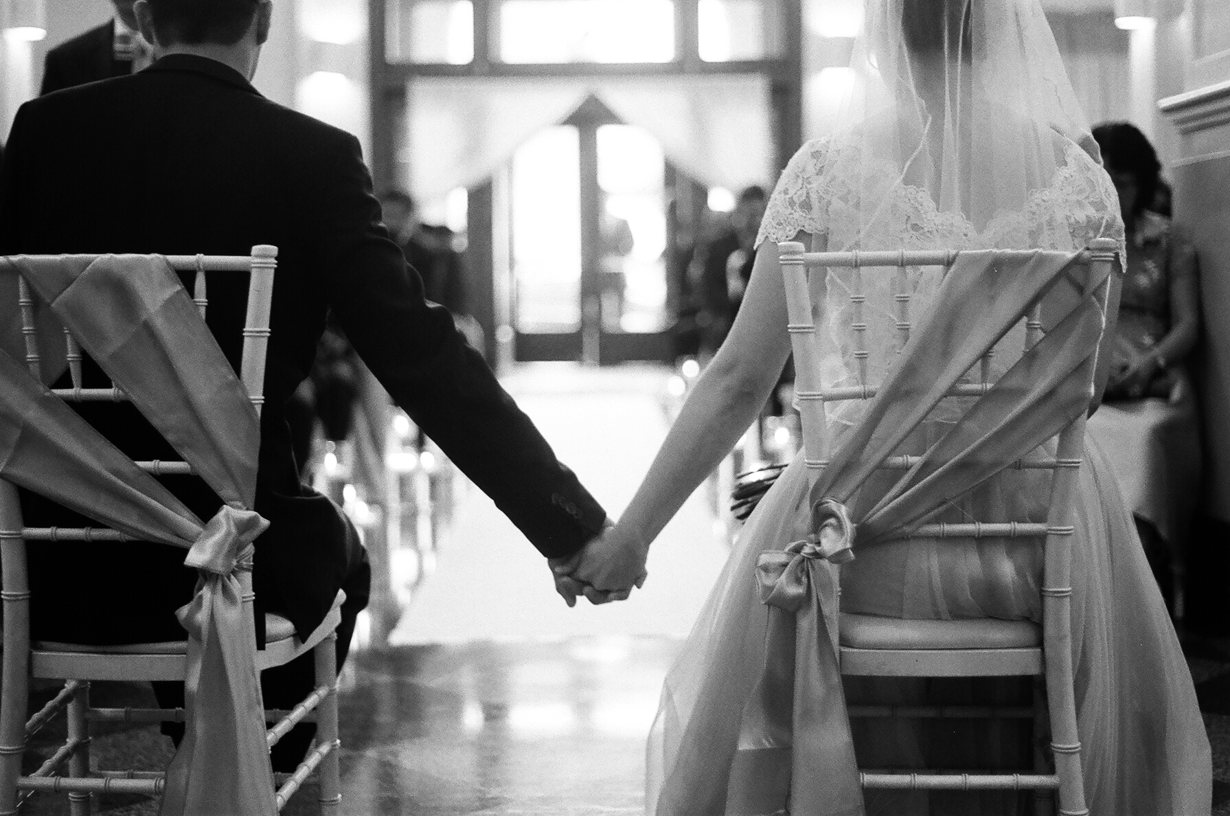  black and white photograph of bride and groom holding hands during the wedding ceremony in Everett Washington Taken by Joseph Barber photography newport beach