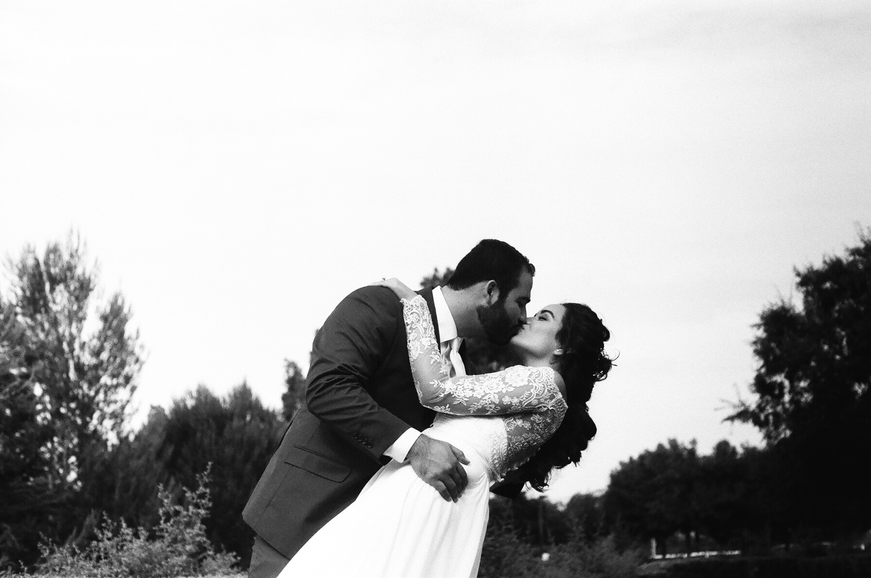 black and white 35mm film Photograph of groom dipping his bride After the first look taken by Joseph Barber wedding photography newport beach