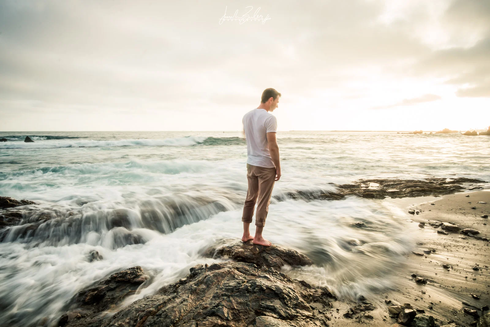 Engagement session photograph of a Fiance posing during during Golden hour at little corona del mar beach
