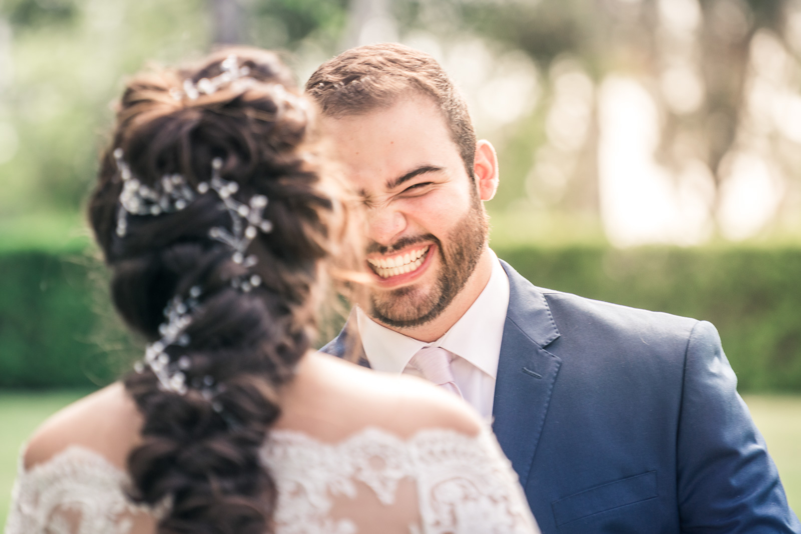 Portrait of the groom turning and smiling  to see his bride during the first book on their wedding day in Brea California