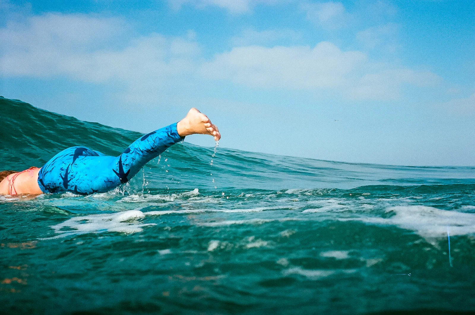 35mm color film Surfing photo shoot in the water at Huntington State Beach with girl surfer duck diving for Get wise fool eco-friendly surf company